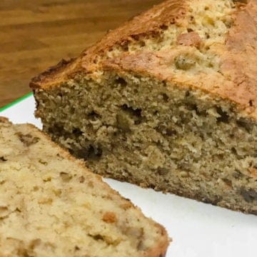 Fresh out of the oven homemade cream cheese banana nut bread with first slice.