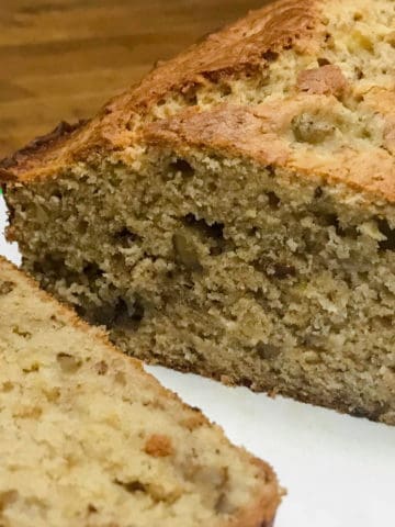 Fresh out of the oven homemade cream cheese banana nut bread with first slice.