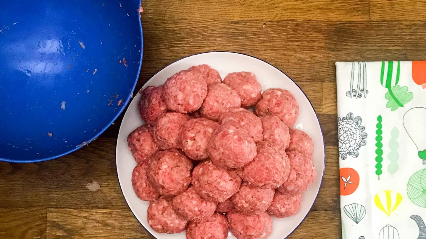 hand formed golf ball sized meatballs resting on white plate