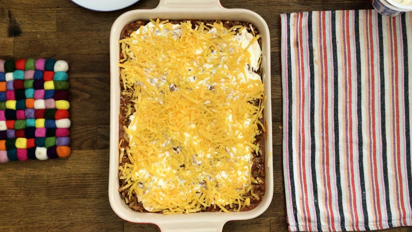 Mexican lasagna with shredded cheddar cheese on top