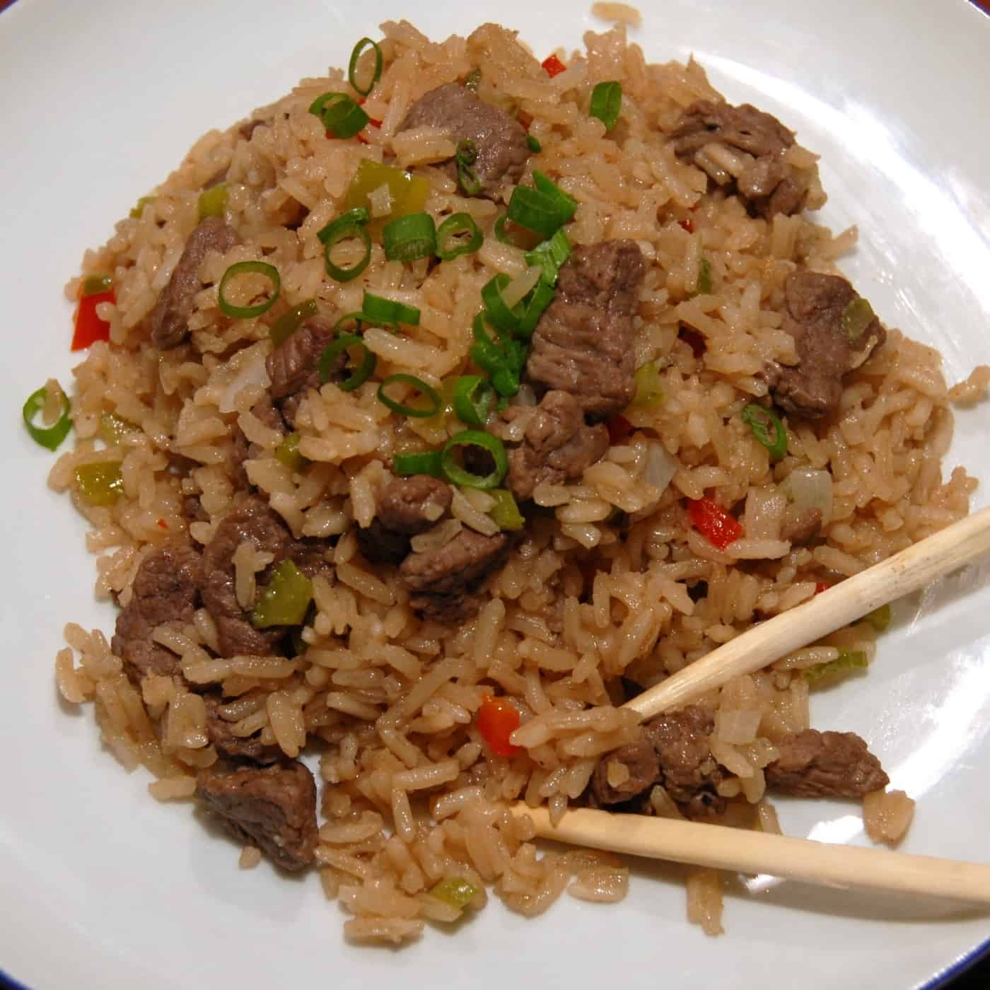 Beef fried rice serve with green onion and chopsticks