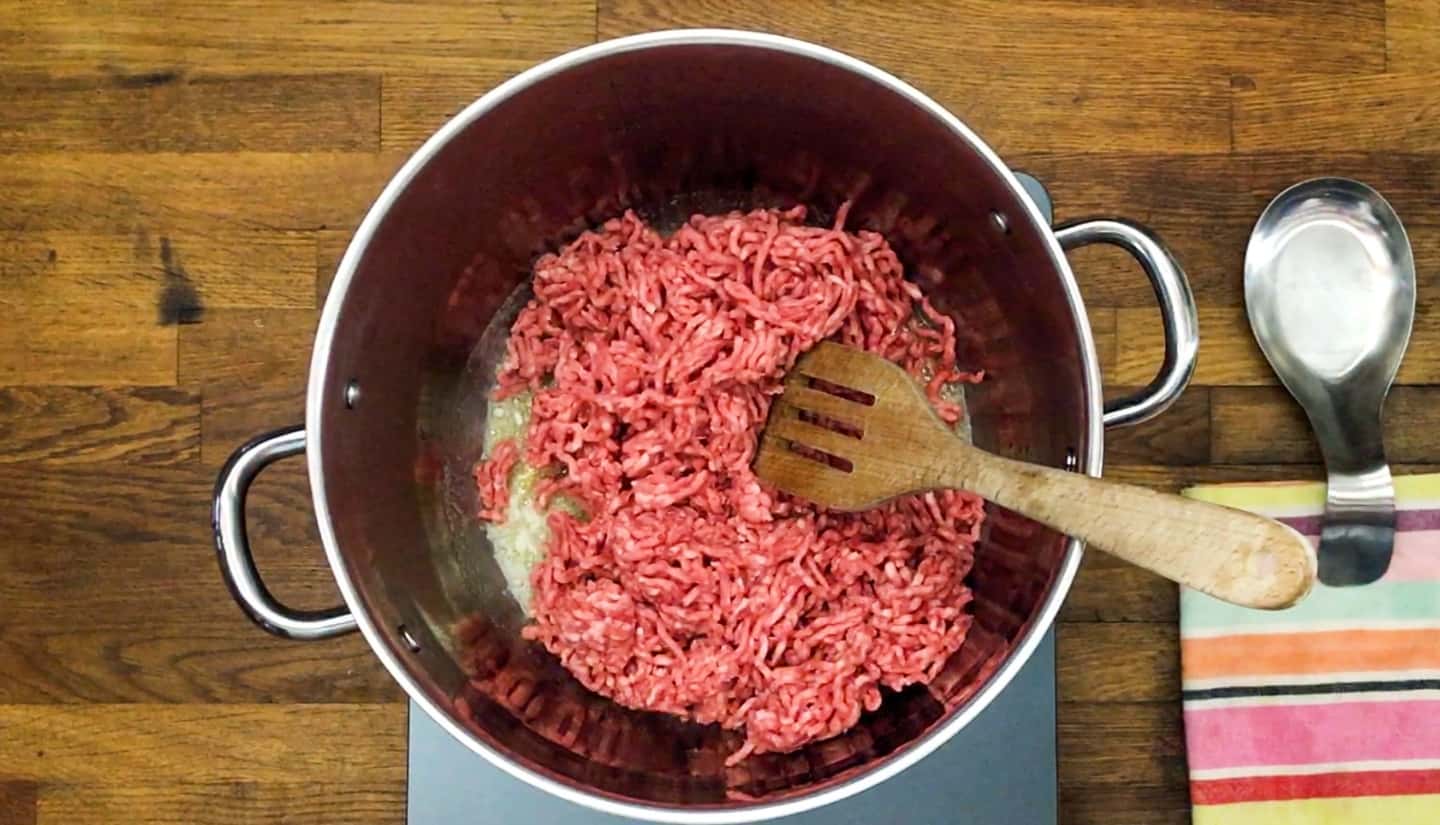 Ground beef in a pot with wood spoon