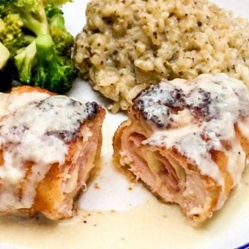 baked chicken cordon bleu with cream sauce on on top serve with broccoli and rice