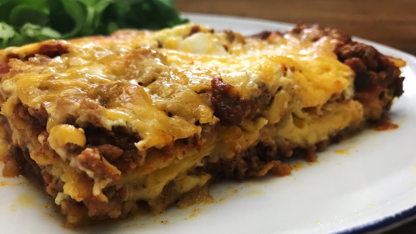 mexican lasagna loaded with a succulent meat mixture, layered with crispy corn tortillas, and smothered with shredded cheddar cheese