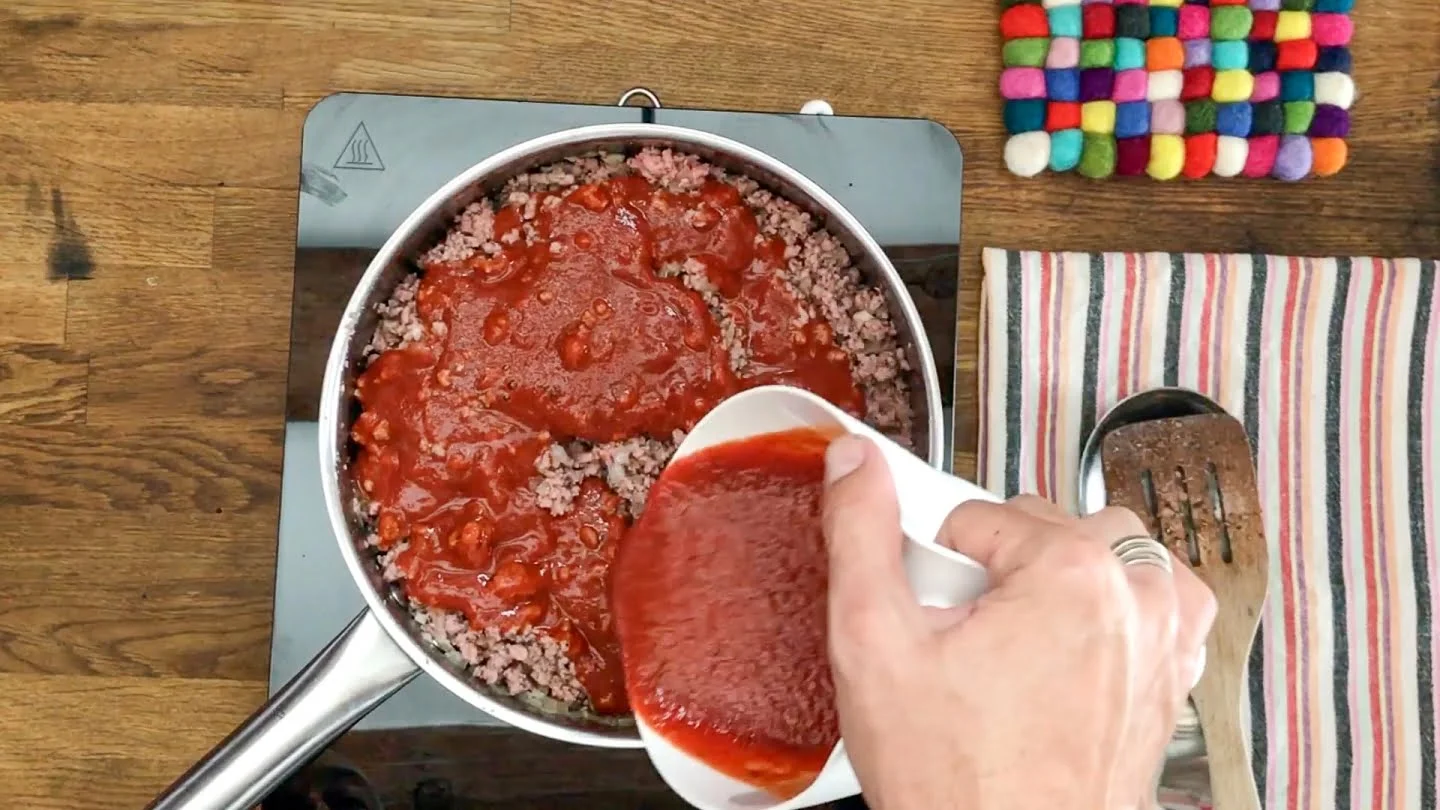 italina marinara sauce poring into ground beef