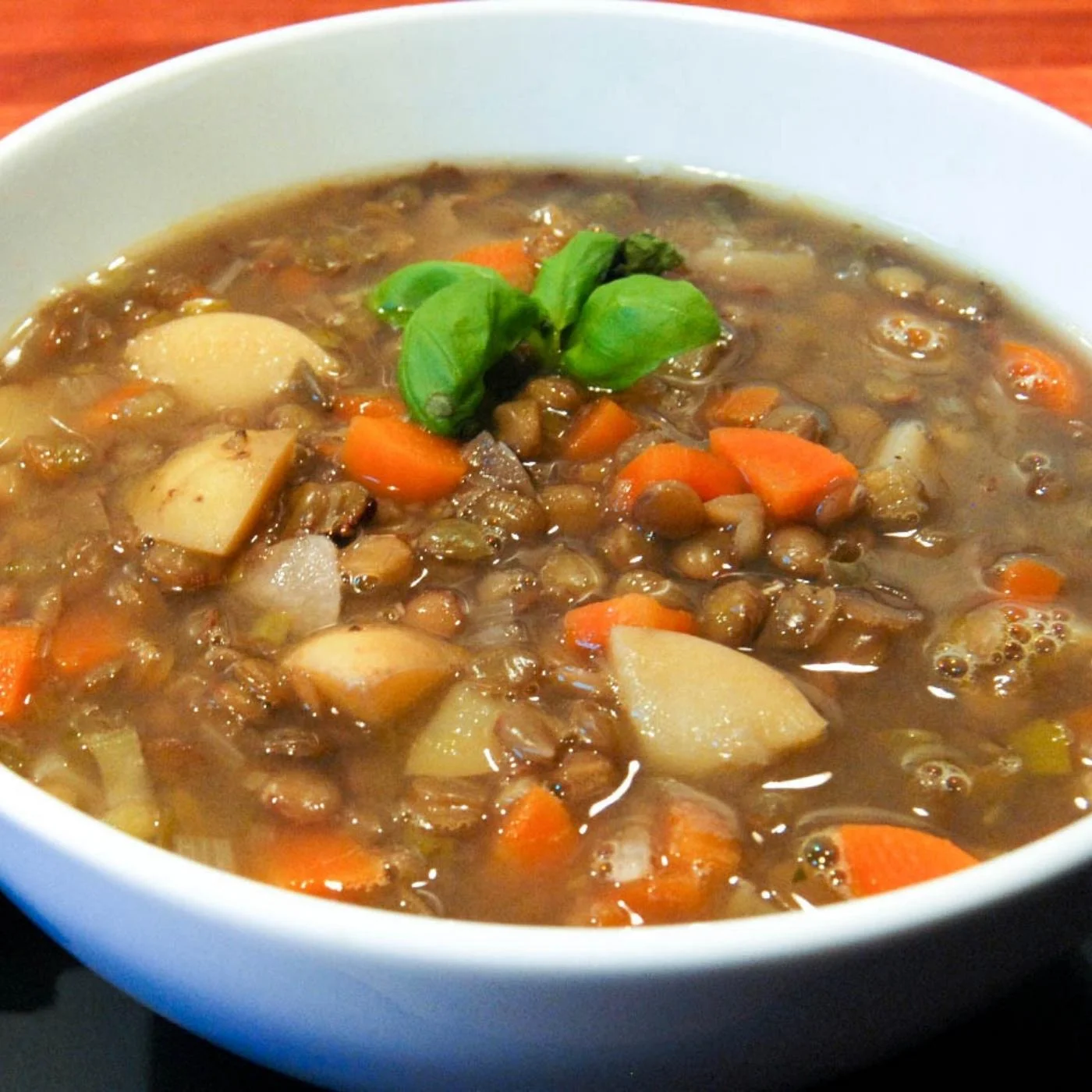 lentil potato soup with carrots in a white bowl