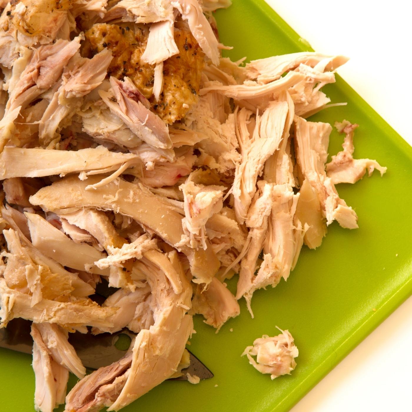 shredded chicken in a green cutting board