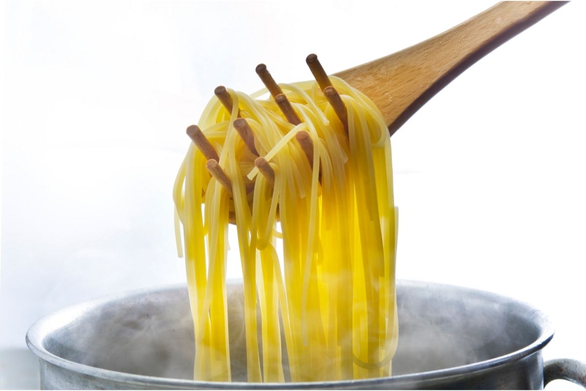 Pasta resting on spoon, lifted from pasta pot on stove