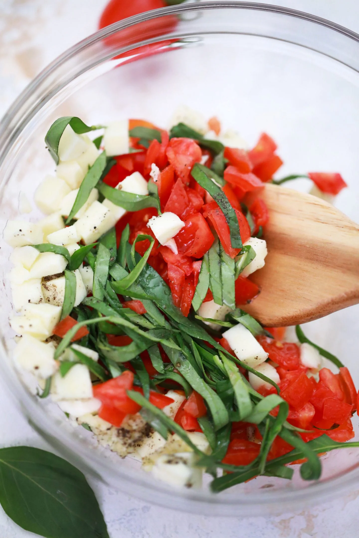 mixing mozzarella basil tomatoes 