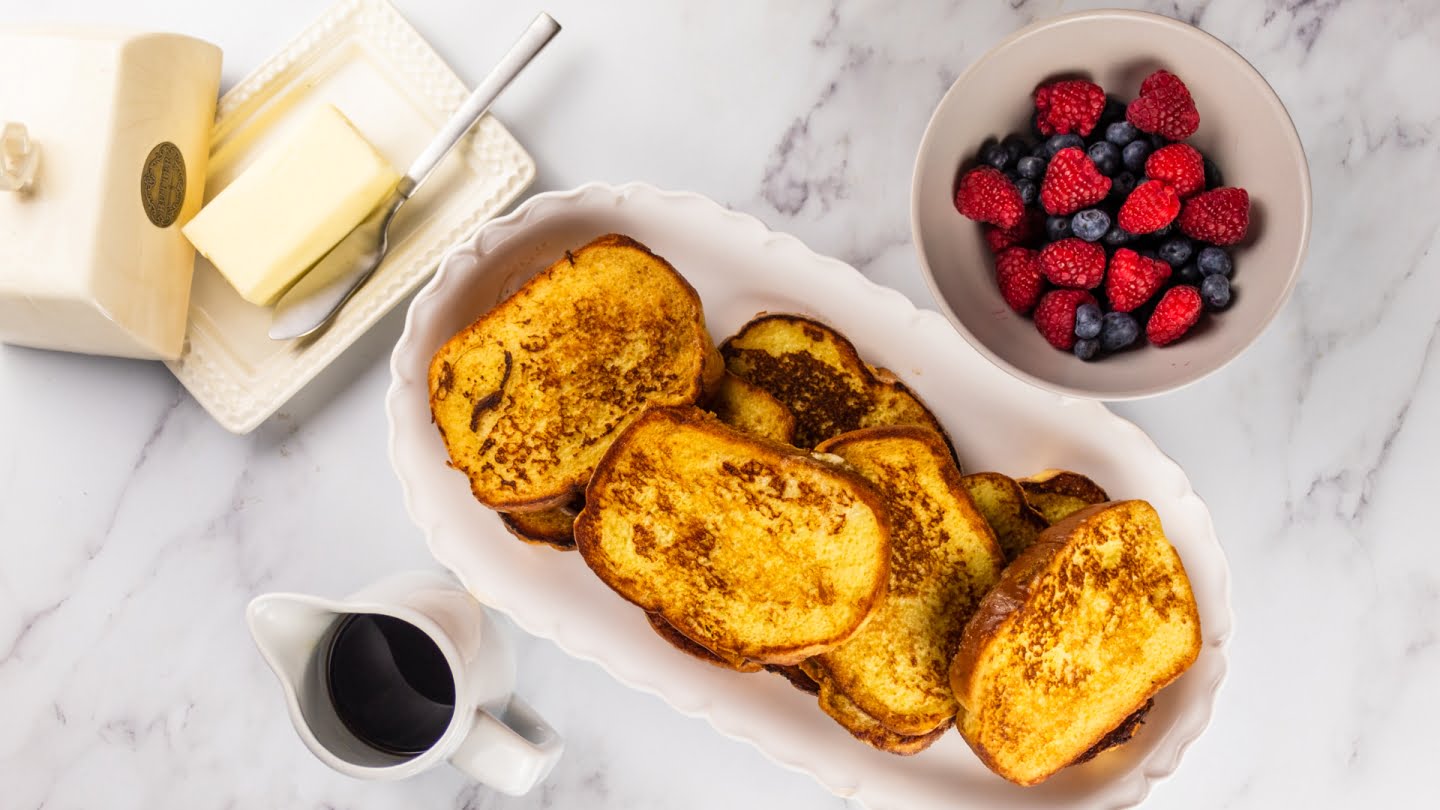 Brioche french toast served with maple syrup, butter, berries