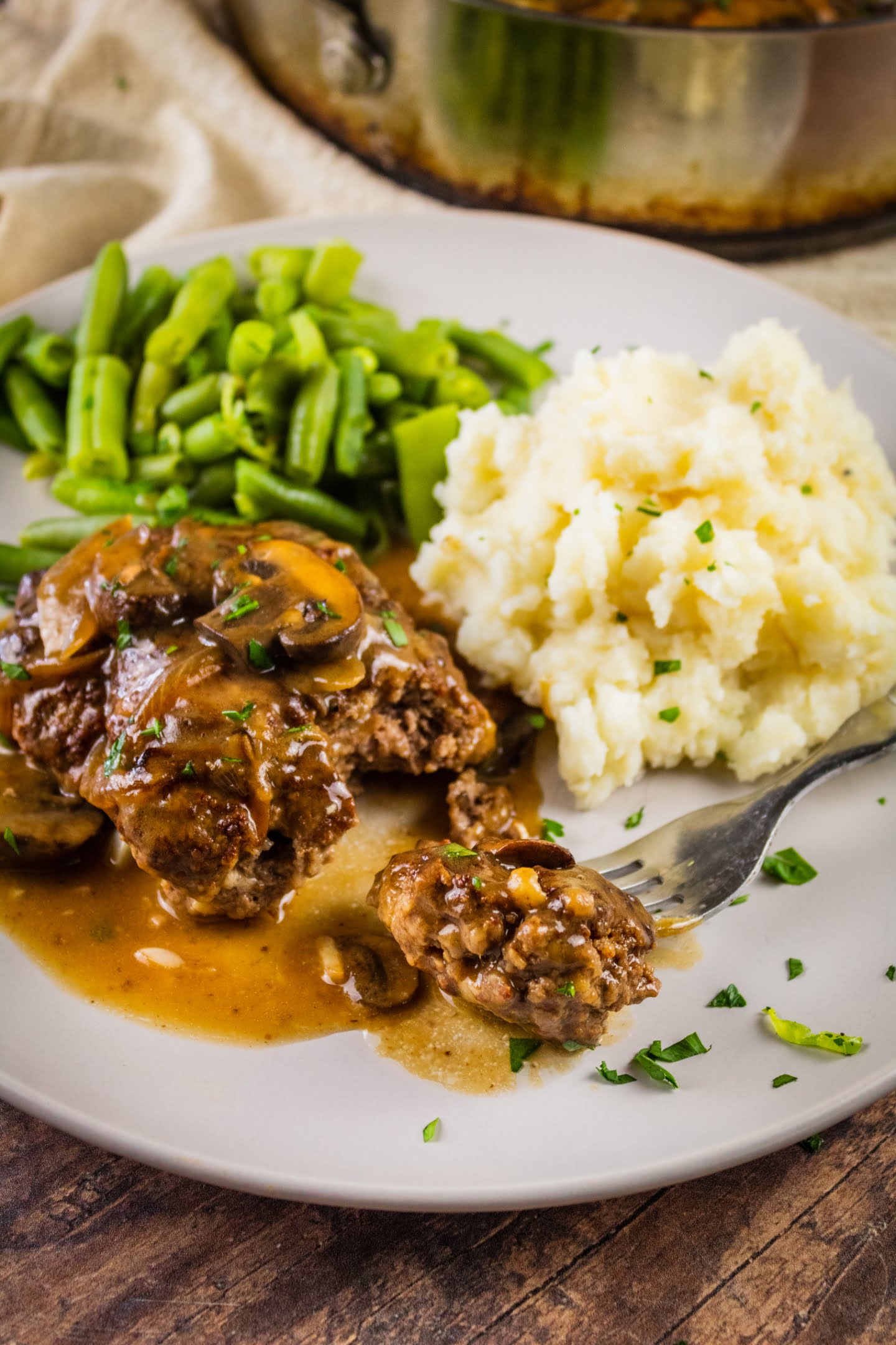 Salisbury steak serving with mashed potatoes and green beans
