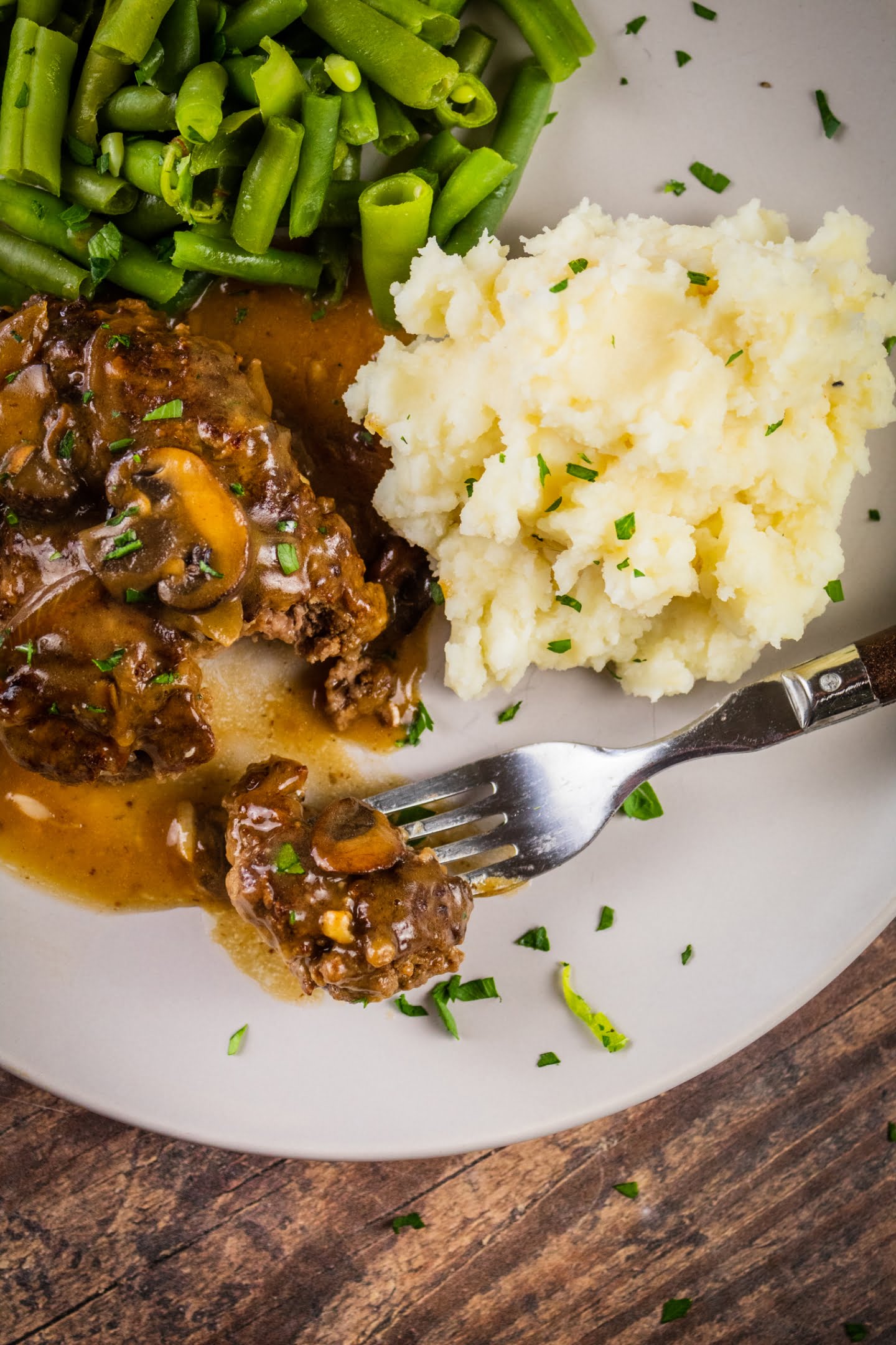 Salisbury Steak serving with mashed potatoes and green beans