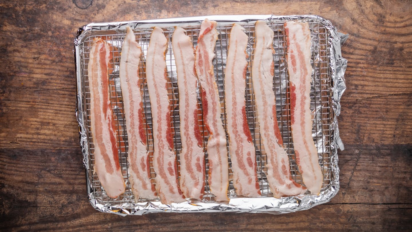 Line a baking sheet with foil and fitted with a rack. Place the bacon slices on top of the rack without overlapping them.
