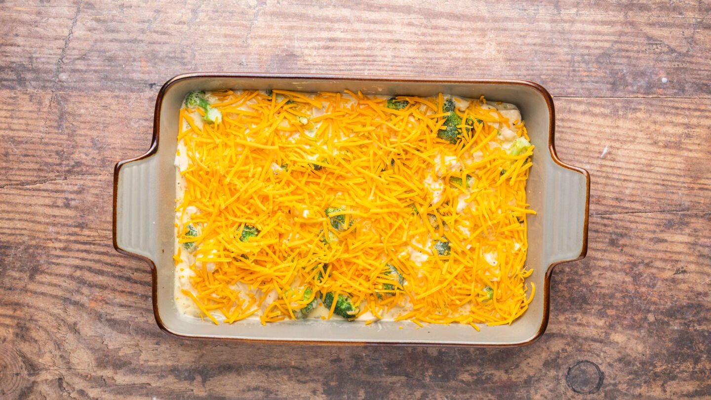Pour the mixture into the prepared casserole dish, top with the remaining cheese, and bake in the preheated oven for 20 minutes.