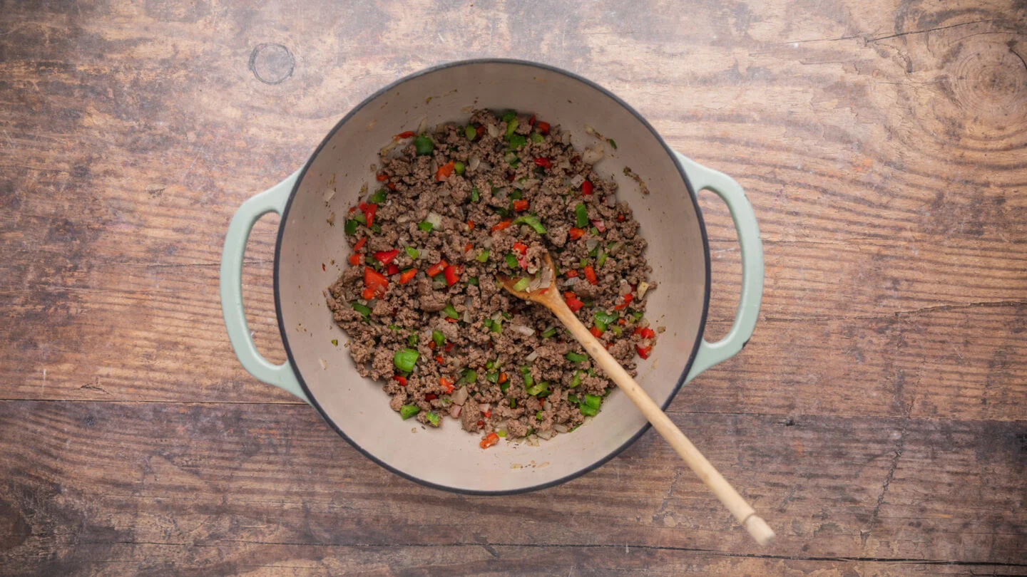 brown the ground beef with the onions, bell peppers, and garlic for 6 to 8 minutes