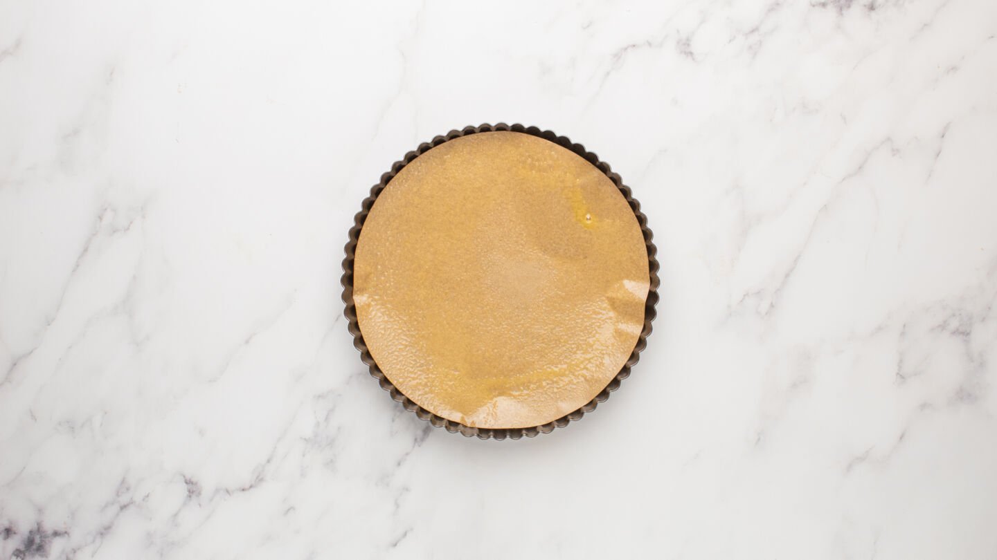Line a 9-inch tart pan with parchment paper