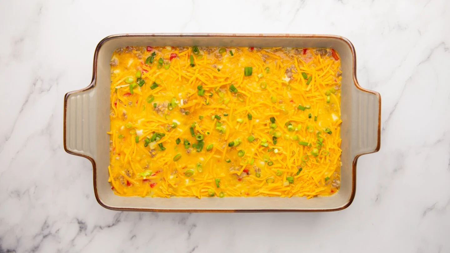 Pour the mixture into the prepared casserole dish and top with the remaining cheese and chopped green onions