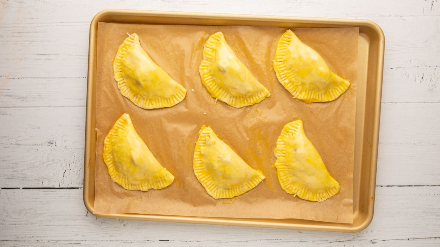 Place the pizza pockets on the prepared baking sheet and brush the tops with the egg wash