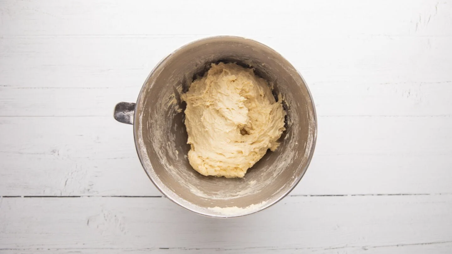 Pour half of the warm water into the bowl of a stand mixer and mix in the sugar and yeast. Leave it for 5 minutes to froth up