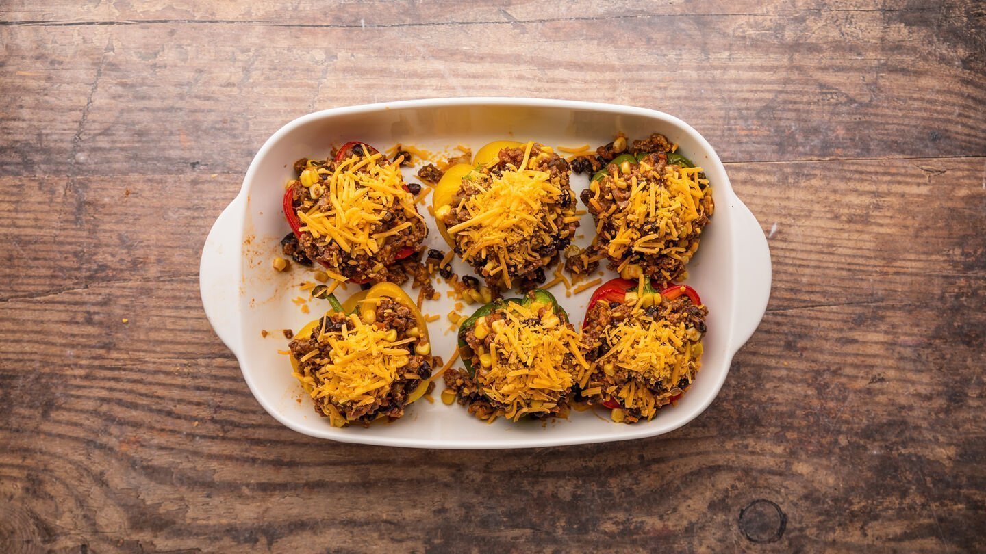 Fill each pepper half with the ground meat mixture and sprinkle the remaining cheese on top.