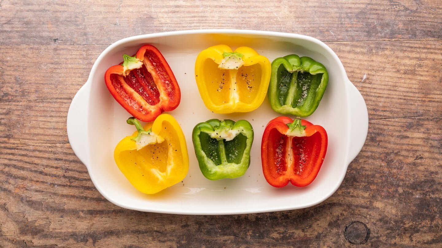 Place the bell peppers on the prepared baking dish (cut side-up) and sprinkle them with salt and pepper