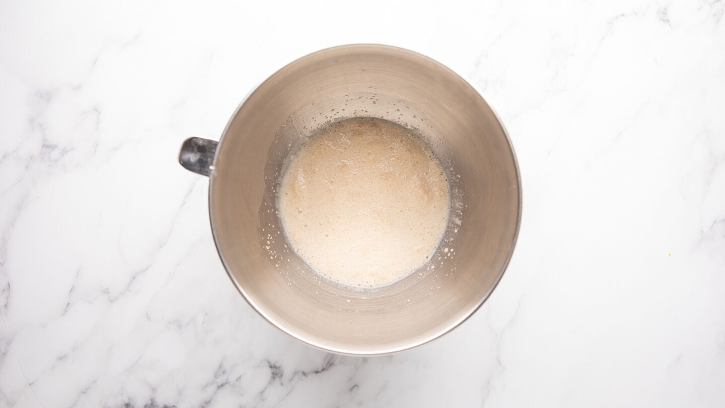 Pour the warm milk, water, sugar, and yeast into the mixing bowl